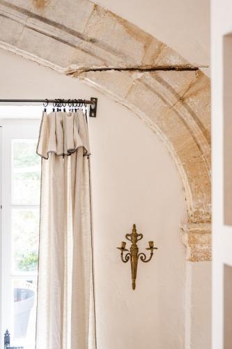 une croix sur un mur à côté d'une fenêtre dans l'établissement Le Jardin Secret - Suite Riad avec Balnéo, à Carpentras