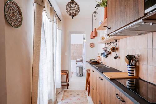 a kitchen with wooden cabinets and a counter top at Le Jardin Secret - Suite Riad avec Balnéo in Carpentras