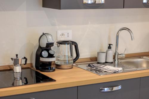 a kitchen counter with a coffee maker and a sink at Revo Apartments - Campelli in Albosaggia