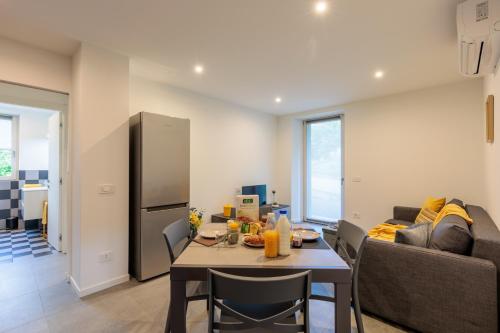 a kitchen and living room with a table and a couch at Revo Apartments - Campelli in Albosaggia