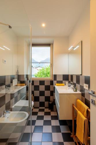 a bathroom with two sinks and a window at Revo Apartments - Campelli in Albosaggia