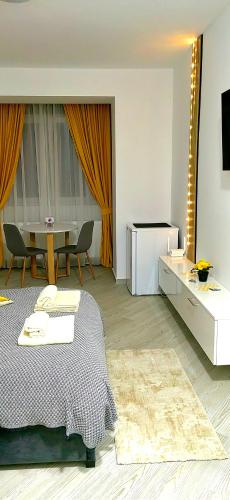 a bedroom with a bed and a table with chairs at Honey Studio in Onești