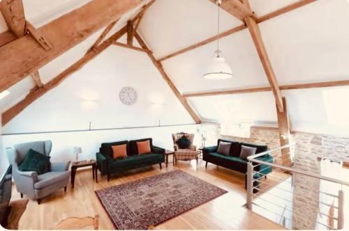 un salon avec des canapés et un mur en pierre dans l'établissement Les Rouges Terres Gites - La Laterie, à Saint-Amand