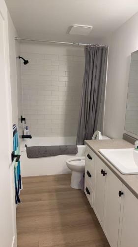a bathroom with a tub and a toilet and a sink at Basement suite -Langley Willoughby in Langley