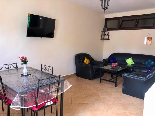 a living room with couches and a table and a tv at APT traditionnel et très bien situé - WIFI & PARKING in Agadir