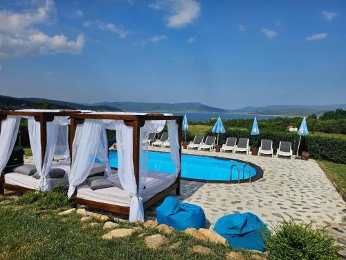 a resort with a pool and chairs and avisorvisorvisor at Vila Lidia in Tsigov Chark