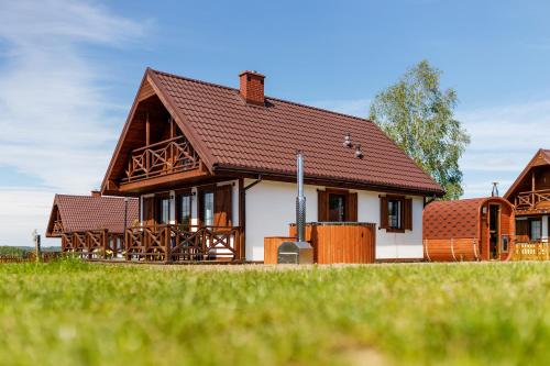 a house with a brown roof at Warmia Prestige in Woryty