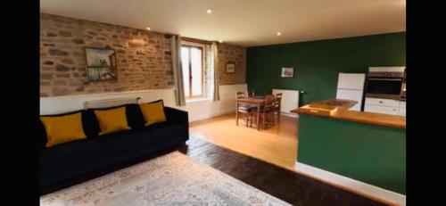 un salon avec un canapé et une cuisine dans l'établissement Les Rouges Terres Gites - La Vieille Grange, à Saint-Amand