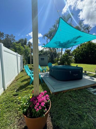 a blue umbrella and some flowers in a yard at Beautiful house with jacuzzi near AnnaMariaIsland in Bradenton