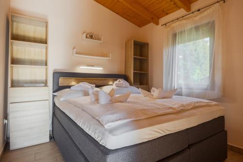 a bedroom with a large bed with a window at Hullám Nyaraló in Balatonmáriafürdő