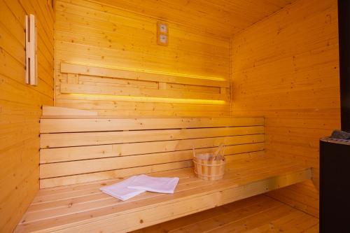 a wooden sauna with two towels and a bucket at Hullám Nyaraló in Balatonmáriafürdő