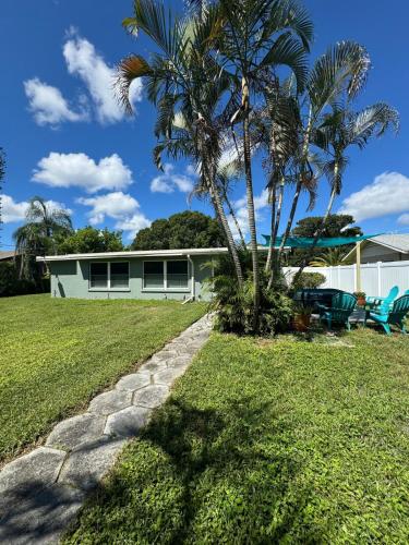 a house with a palm tree and a stone path at Beautiful house with jacuzzi near AnnaMariaIsland in Bradenton