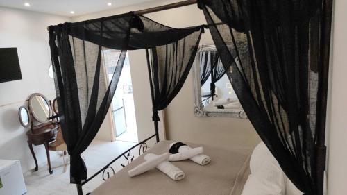 a bedroom with a black canopy bed with a mirror at Αnchor Suites in Thessaloniki