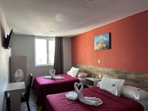 ein Hotelzimmer mit zwei Betten, auf denen Handtücher liegen in der Unterkunft Hotel Teresita in Puebla