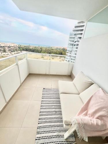 a balcony with a white couch and a rug at Luxury Canet in Canet de Berenguer