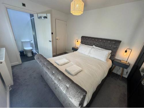 a bedroom with a large bed with two towels on it at Southwest Stays in Bristol