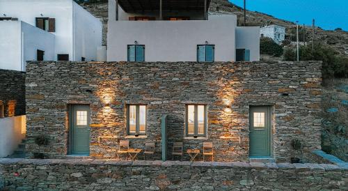 a stone building with green doors and windows at Nysa Kea - A Cycladic House in Korissia