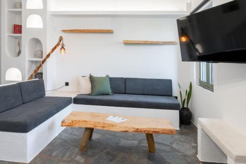 a living room with a couch and a tv at Nysa Kea - A Cycladic House in Korissia
