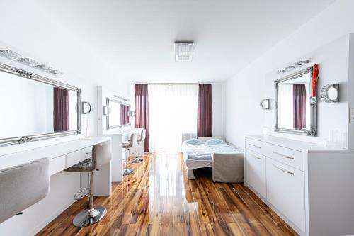 a bathroom with white cabinets and a sink and mirror at TP Spacious Stylish Free parking in Szeged