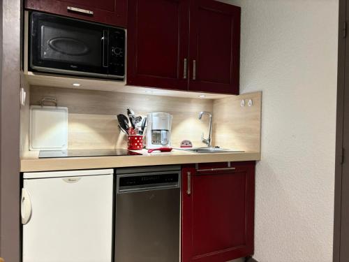une petite cuisine avec un évier et un micro-ondes dans l'établissement Résidence LE DE 3 - 2 Pièces pour 4 Personnes MAE-1681, à Aime La Plagne