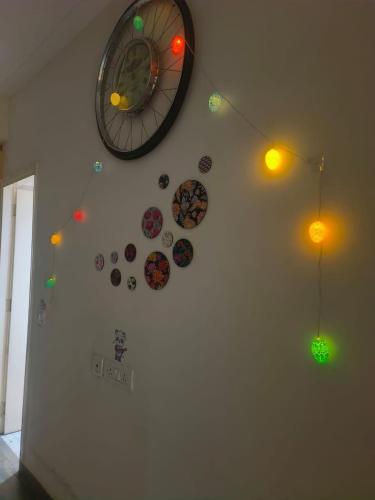 a wall with a clock and some stickers on it at Night View Apartment in Ghaziabad