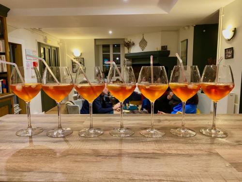 a row of wine glasses sitting on a wooden table at Auberge de Perchades in Bilhères en Ossau