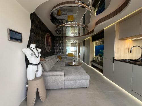 Il comprend un salon avec un canapé gris et une cuisine. dans l'établissement Le Bb Port Nature Coursives, au Cap d'Agde