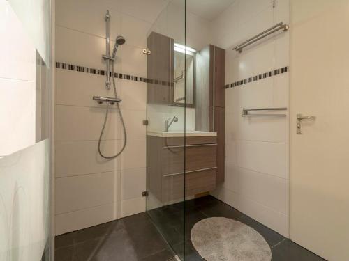 a bathroom with a shower and a glass shower stall at Apartment in Julianadorp near the beach in Julianadorp