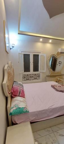a small room with a bed and a mirror at الساحل الشمالي in Borg El Arab