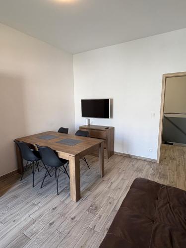 a room with a table and chairs and a tv at Apartamenty Na Fali in Kołobrzeg