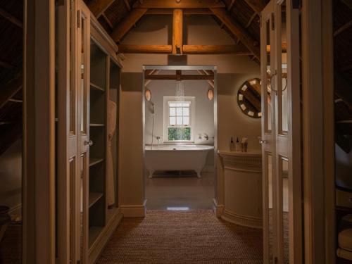 a bathroom with a bath tub and a sink at The Doolhof Country House in Wellington