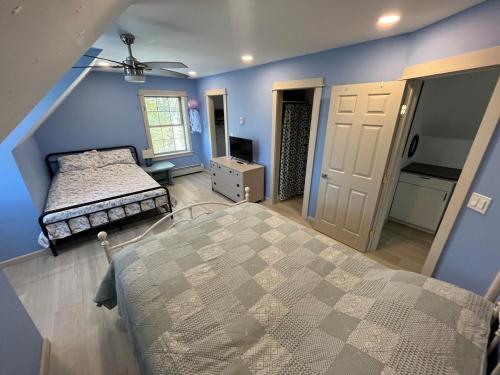 a bedroom with a bed and blue walls at Wolf Pond House 3 Miles to Lake Placid in Lake Placid