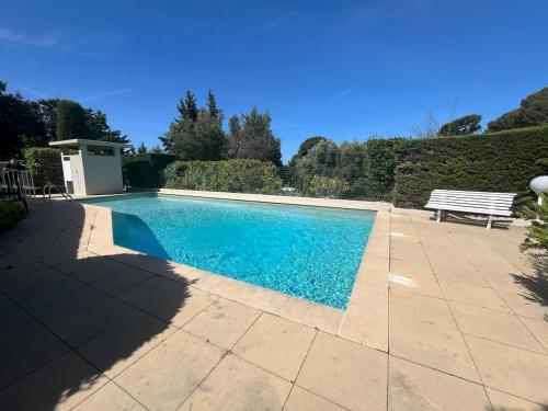 - une piscine avec un banc dans la cour dans l'établissement T2 avec terrasse et accès piscine, à Cassis