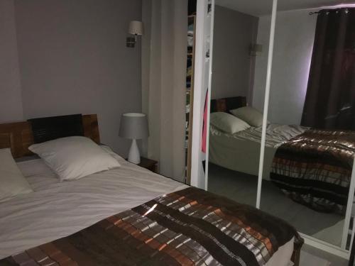 une chambre avec un lit et un miroir dans l'établissement T2 avec terrasse et accès piscine, à Cassis