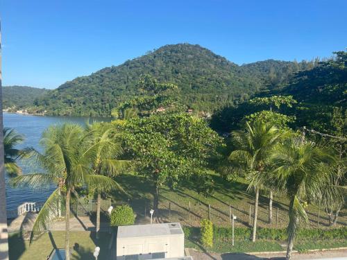 a view of a body of water with palm trees at Flat Porto Marina Mont Blanc in Mangaratiba