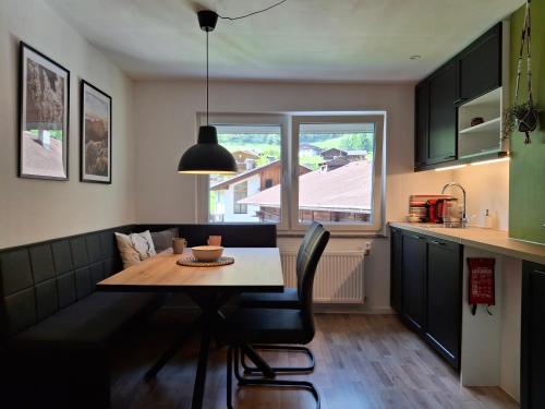 a kitchen with a dining table and a window at Ferienhaus Enzian in Prägraten am Großvenediger