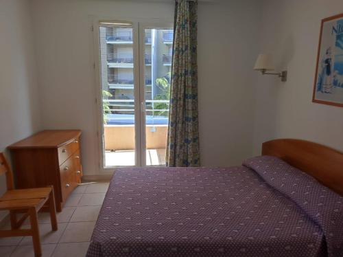 - une chambre avec un lit et une porte donnant sur un balcon dans l'établissement Gran Cap Apartment, à Roquebrune-Cap-Martin