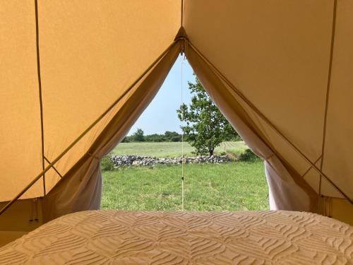 une tente avec vue sur un champ dans l'établissement Tipi au Murmure du Champs, à Montclus