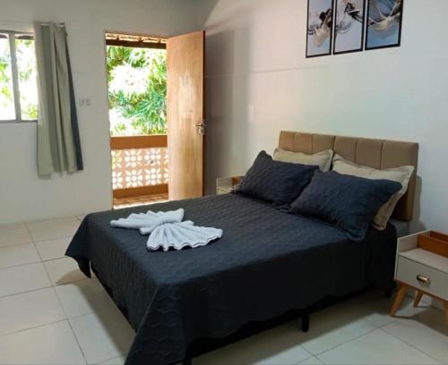 a bedroom with a bed with blue sheets and a window at Pousada Sinai in Viçosa