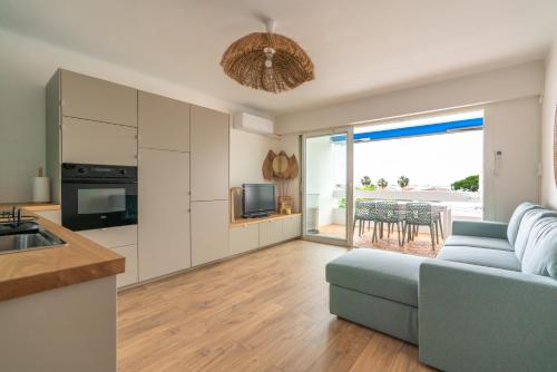 Il dispose d'une cuisine et d'un salon avec un canapé et une télévision. dans l'établissement Bleu Camargue, au Grau-du-Roi