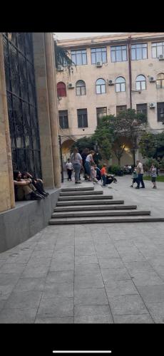 a group of people sitting on steps in front of a building at Sweet Rooms Inn in Tbilisi City