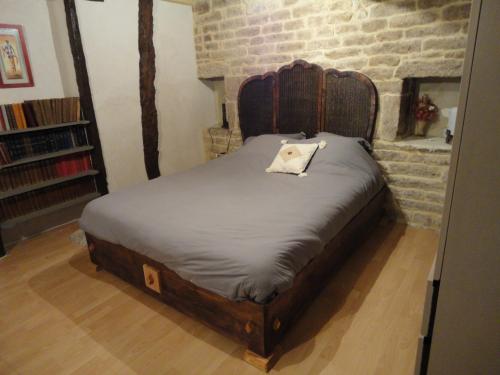 - un lit avec une tête de lit en bois dans l'établissement wellstay, à Montpezat