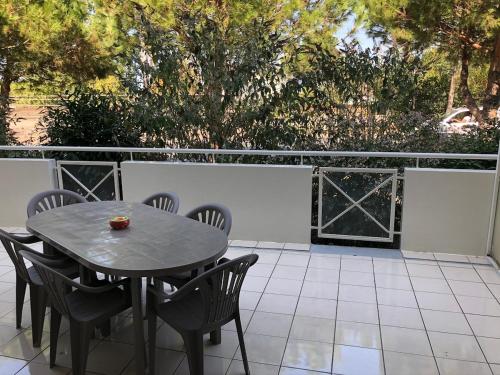 une table et des chaises assises sur une terrasse dans l'établissement Résidence privée grande terrasse piscine privée plage port gare, à Gujan-Mestras