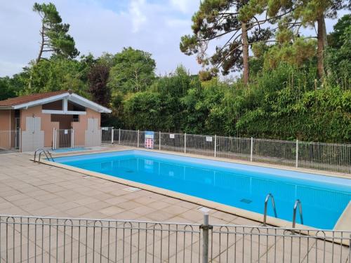 une grande piscine bleue à côté d'une clôture dans l'établissement Résidence privée grande terrasse piscine privée plage port gare, à Gujan-Mestras
