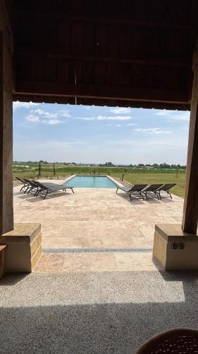 une vue d'une piscine avec des bancs autour dans l'établissement Cottage RG, à Lamothe-Landerron