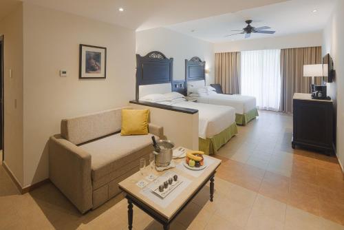 a hotel room with a couch and a bed at Occidental at Xcaret Destination - All Inclusive in Playa del Carmen