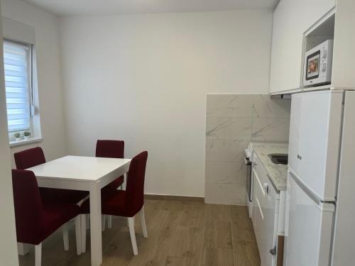 a kitchen with a white table and chairs and a refrigerator at Harizma lux centar in Popadić
