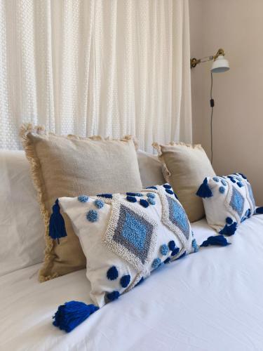 a bed with blue and white pillows on it at Cosy Flat with IPTV, BB gear Married couples only in Tangier