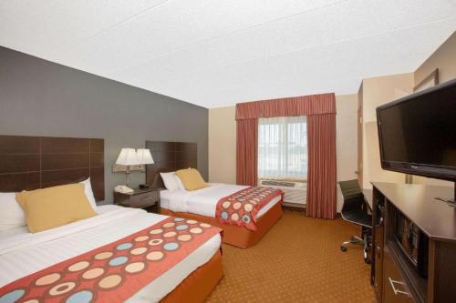 a hotel room with two beds and a flat screen tv at American Coralville Iowa City Iowa in Coralville