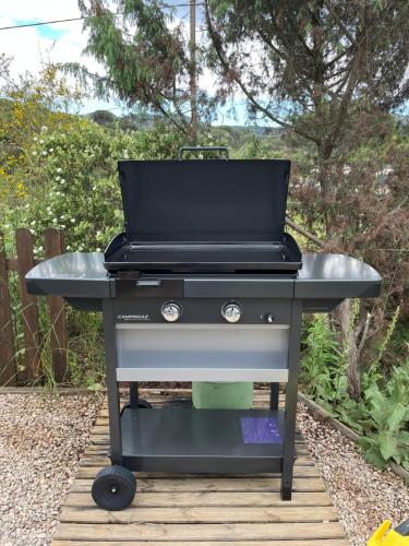 - un grill installé au-dessus d'une terrasse en bois dans l'établissement Mobil home familial, au Muy